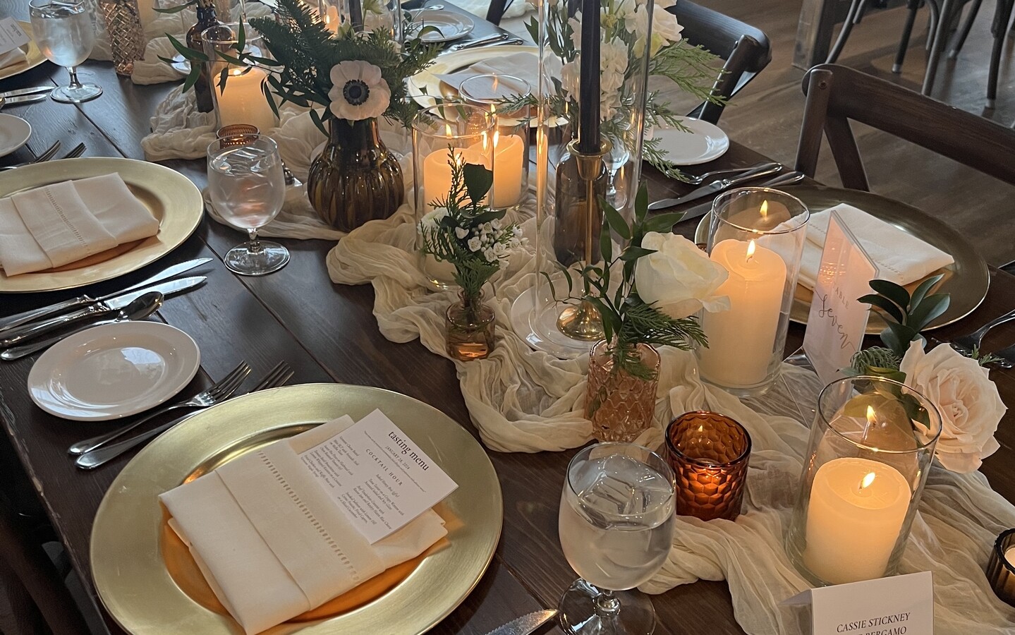 ivory hemstitch napkin on gold charger with candle light